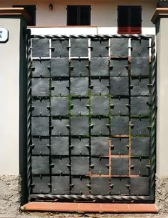 a gate made out of concrete blocks with grass growing on the sides and in between