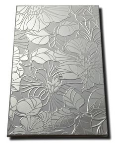 a metal sheet with flowers and leaves etched on the side, as well as an image of