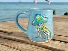 a blue coffee mug with a jellyfish design on it