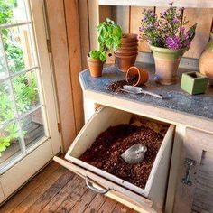 an open drawer with plants in it on top of a counter