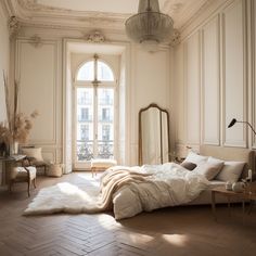 a bedroom with white walls and wood flooring has a large bed in the middle