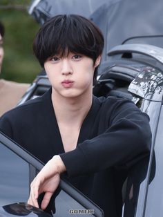 a young man leaning out the window of a car