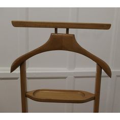 a wooden coat rack in front of a white door