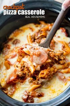 a spoon full of pasta and meat covered in sauce on top of a pan filled with cheese