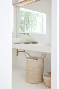 a bathroom with a sink, mirror and basket