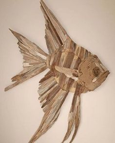 a fish made out of drift wood on a wall