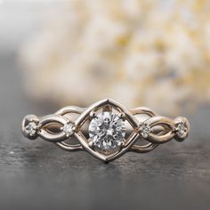 a close up view of an engagement ring with a diamond in the center and two smaller diamonds on each side