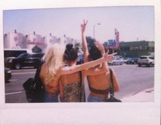 two women standing next to each other in front of a parking lot