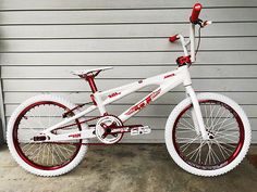 a white and red bike parked in front of a garage