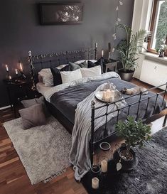 a bed room with a neatly made bed and lots of candles on the side tables