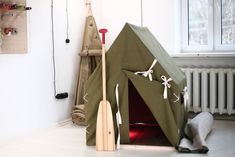 a teepee tent with some tools in front of it on the floor next to a radiator