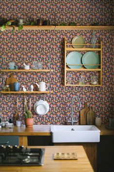 a kitchen area with a sink, stove and shelves