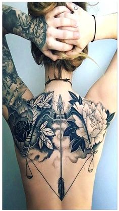 a woman's back with tattoos and flowers on it