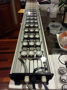 an array of glasses are lined up on a long counter in the middle of a kitchen