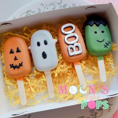 three halloween pops are in a box on the table