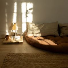 a living room with a couch, table and lamp on the floor in front of it