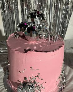 there is a pink cake with silver decorations on the top and one has a disco ball