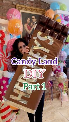 a woman holding a giant chocolate bar with the words candy land diy part 1