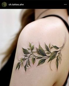 a woman's shoulder with green leaves on it