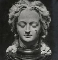 an old black and white photo of a woman's head with her eyes closed