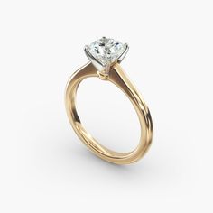 a yellow gold engagement ring with a single diamond in the center, on a white background