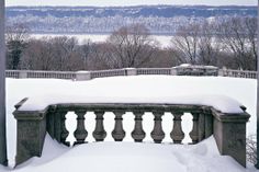 a bench covered in snow with mountains in the background