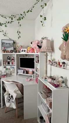 a white desk topped with a computer monitor next to a shelf filled with stuffed animals