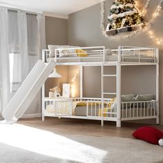 a white bunk bed sitting next to a christmas tree