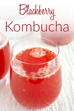 two glasses of blackberry kombucha on a white tablecloth with the words blackberry kombucha