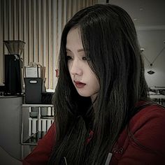 a woman with long black hair sitting in front of a computer