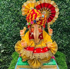 a statue of an elephant wearing a red and yellow outfit