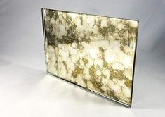 a marbled surface with gold flecks is shown in this glass display case