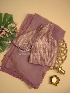 The saree set comes in a lilac pink hue. Crafted from pure organza fabric, the saree is adorned with intricate maggam work buttis throughout, giving you an elegant look. The cut work around the borders of the saree makes it unique. The set also includes a pre-stitched banaras silk blouse with a back opening, giving the overall outfit a classy look. The saree is crafted from a pure organza fabric. Saree is further adorned with a maggam work buttis allover. The pre stitched blouse is crafted from Lavender Organza Dupatta With Resham Embroidery, Traditional Lavender Organza Dupatta, Purple Tissue Silk Saree Set, Lavender Organza Dupatta With Zari Work, Traditional Lavender Blouse Piece With Pallu, Lavender Saree With Pallu For Eid, Traditional Lavender Blouse Piece For Diwali, Lavender Cutdana Saree For Diwali, Fitted Purple Organza Saree