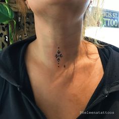 a woman with a black cross tattoo on her neck