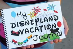 a child holding a sign that says, my disneyland vacation journal