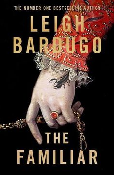 the familiar by leigh bardugo is shown in this book cover image, which features a hand holding a chain and wearing a red hat