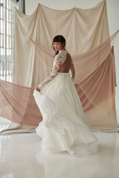 a woman in a white dress is posing for the camera