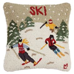 a pillow with skiers on it and the words ski written in red, white and blue