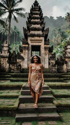 a woman in a dress walking up some steps