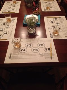 a wooden table topped with glasses and papers