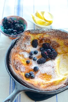 a pancake with blueberries and powdered sugar on top is sitting on a table