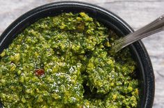 a black bowl filled with green pesto