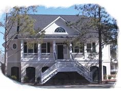 a white house with black shutters on the front porch and stairs leading up to it