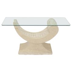 a glass table with a stone base and an oval design on the top, against a white background