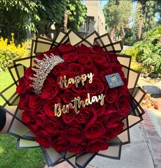 a bouquet of red roses with the words happy birthday written in gold on it and surrounded by other flowers