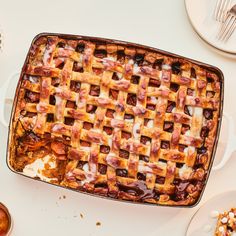 a pie sitting on top of a white table next to plates and utensils