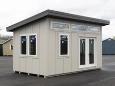 a small building with windows and doors on the outside, in an empty parking lot