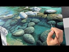 a person is drawing rocks in the water with colored pencils and an easel