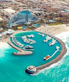 an aerial view of a marina with boats and hotels in the background