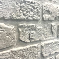 a white brick wall with cracks in it